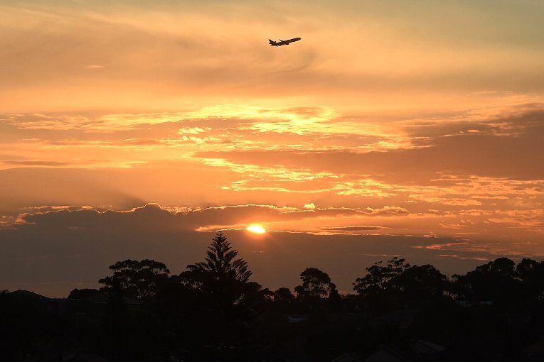Avion en approche au coucher du soleil