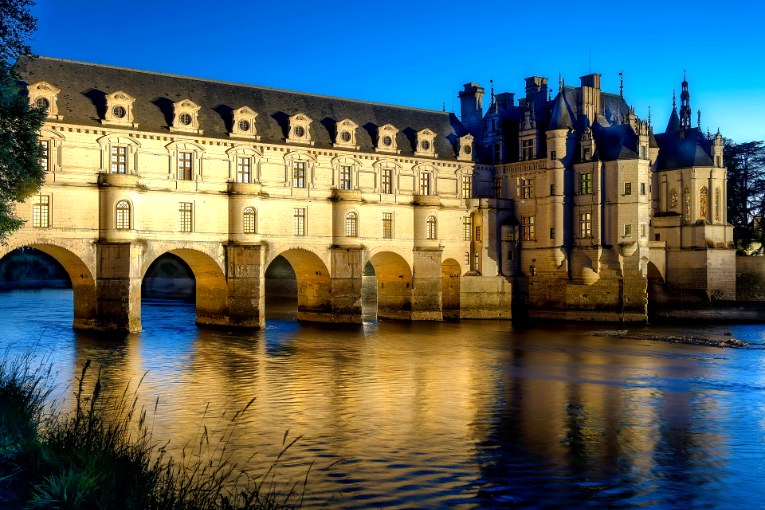 Le château de Chenonceau illuminé de nuit, reflété dans le Cher